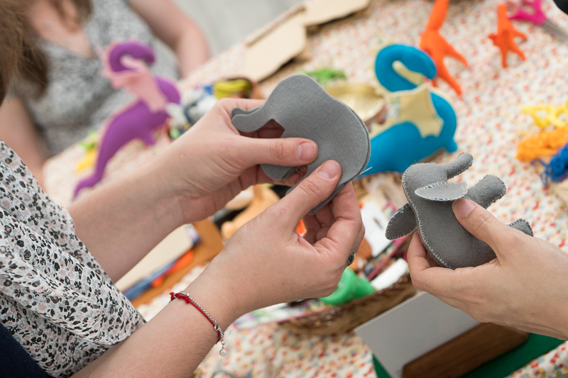 NSG Project in North Vancouver- Toy Making Workshop. TWo people making grey felt elephants.